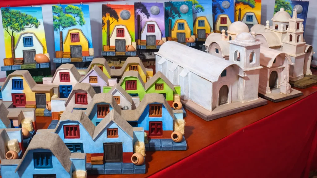 Artesanía arquitectónica de Tacna con maquetas de casas tradicionales e iglesias en exposición con colores vivos en alta resolución