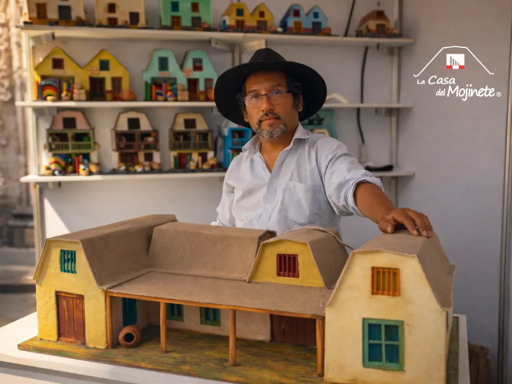 Artesano Sergio Ilich junto a maqueta de casa tradicional de mojinete tacneña con detalles arquitectónicos hechos a mano