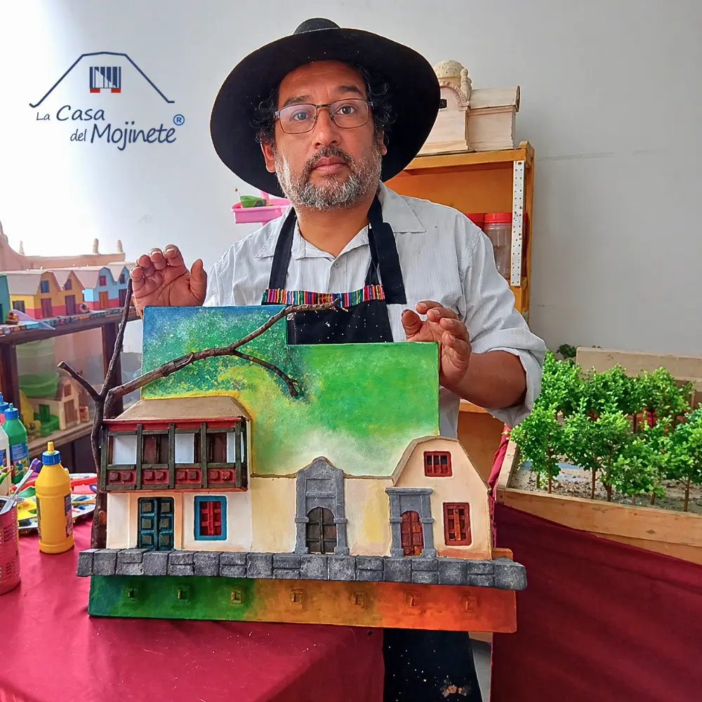 Sergio Loaiza artesano de Casa del Mojinete en Tacna mostrando maqueta de arquitectura tradicional con técnica de arena encolada