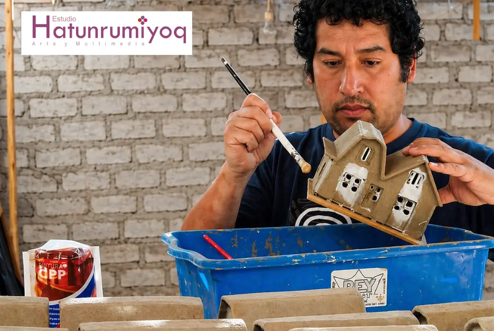 Sergio Loaiza aplicando técnica de arena encolada en maqueta de arquitectura tradicional en Tacna