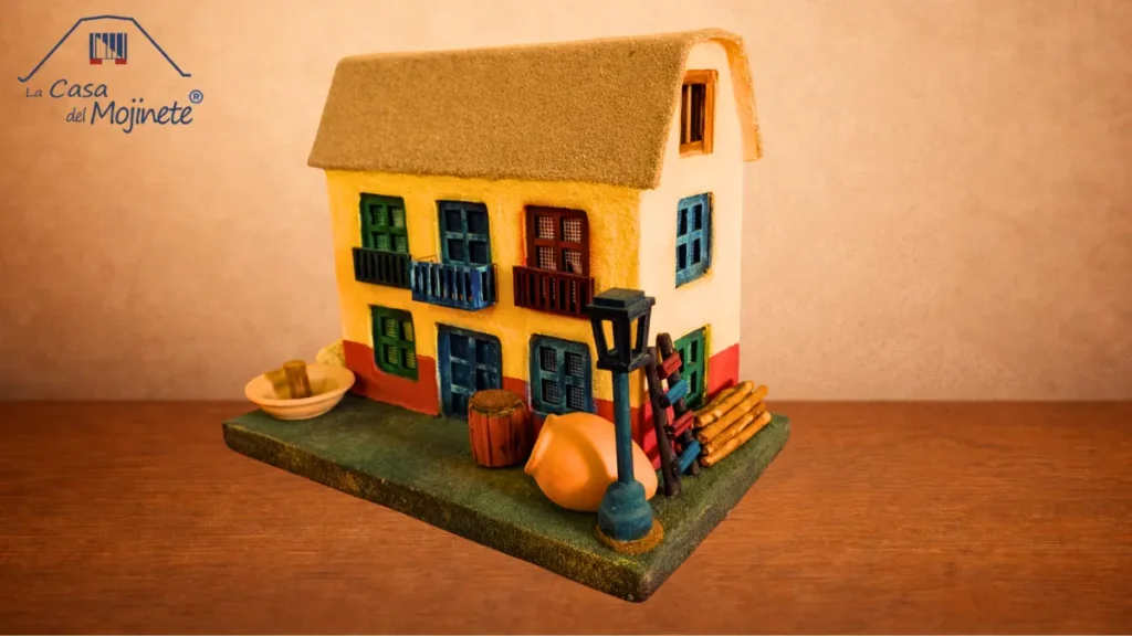 Maqueta artesanal de casa con techo de mojinete hecha con técnica de arena encolada, estilo tradicional tacneño