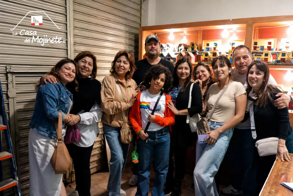 Grupo de visitantes durante una visita guiada en el Museo de Arte Popular en Tacna observando artesanía arquitectónica en arena encolada